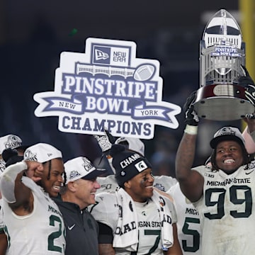 Dec 27, 2019; Bronx, New York, USA; Michigan State defensive tackle Raequan Williams (99) and defensive end Kenny Willekes (48) celebrate with the trophy after defeating the Wake Forest Demon Deacons in the Pinstripe Bowl at Yankee Stadium. Mandatory Credit: Brad Penner-Imagn Images