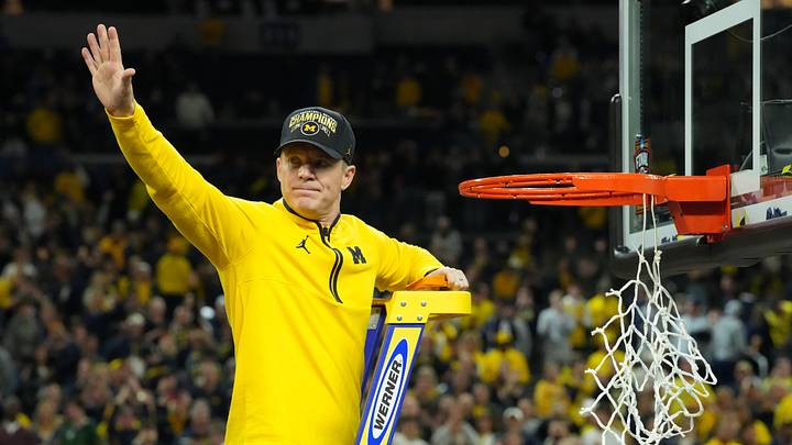 Apr 6, 2026; Indianapolis, IN, USA; Michigan Wolverines head coach Dusty May waves to the crowd as he cuts down the net after defeating the Connecticut Huskies in the national championship of the Final Four of the men's 2026 NCAA Tournament at Lucas Oil Stadium. Mandatory Credit: Robert Deutsch-Imagn Images