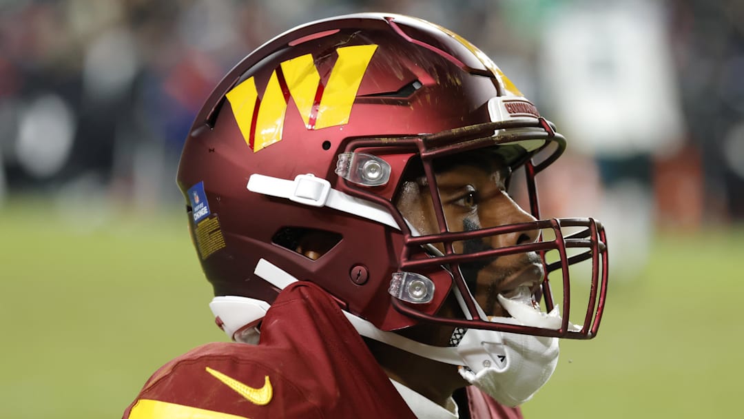 Dec 20, 2025; Landover, Maryland, USA; Washington Commanders wide receiver Treylon Burks (13) sits on the field after a play against the Philadelphia Eagles during the second half at Northwest Stadium. Mandatory Credit: Amber Searls-Imagn Images