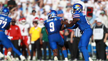 Kansas Jayhawks quarterback Jalon Daniels (6) hands off the ball to Kansas Jayhawks running back Daniel Hishaw Jr. (9) during the game between Fresno State and Kansas at David Booth Kansas Memorial Stadium on Aug. 23, 2025.