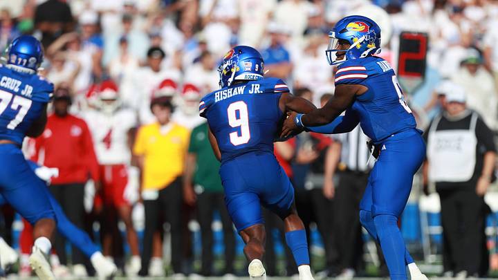 Kansas Jayhawks quarterback Jalon Daniels (6) hands off the ball to Kansas Jayhawks running back Daniel Hishaw Jr. (9) during the game between Fresno State and Kansas at David Booth Kansas Memorial Stadium on Aug. 23, 2025.