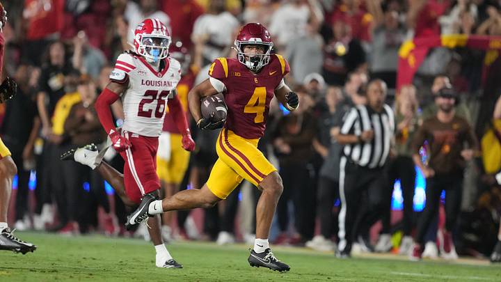 Sep 12, 2026; Los Angeles, California, USA; Southern California Trojans wide receiver Trent Mosley (4) carries the ball on an 86-yard punt return against Louisiana Ragin' Cajuns safety Kerry Wilson (26) in the first half at United Airlines Field at Los Angeles Memorial Coliseum. Mandatory Credit: Kirby Lee-Imagn Images
