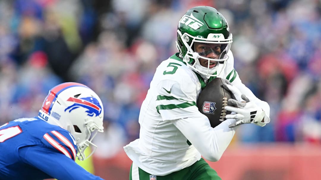 Dec 29, 2024; Orchard Park, New York, USA; New York Jets wide receiver Garrett Wilson (5) tries to get past Buffalo Bills safety Cole Bishop (24) after making a catch in the second quarter at Highmark Stadium. Mandatory Credit: Mark Konezny-Imagn Images