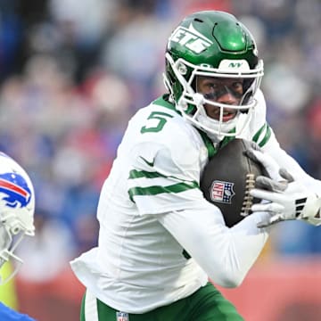 Dec 29, 2024; Orchard Park, New York, USA; New York Jets wide receiver Garrett Wilson (5) tries to get past Buffalo Bills safety Cole Bishop (24) after making a catch in the second quarter at Highmark Stadium. Mandatory Credit: Mark Konezny-Imagn Images