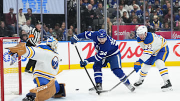 Dec 15, 2024; Toronto, Ontario, CAN; Toronto Maple Leafs center Auston Matthews (34) battles for the puck in front of the net with Buffalo Sabres defenseman Mattias Samuelsson (23) during the first period at Scotiabank Arena. Mandatory Credit: Nick Turchiaro-Imagn Images