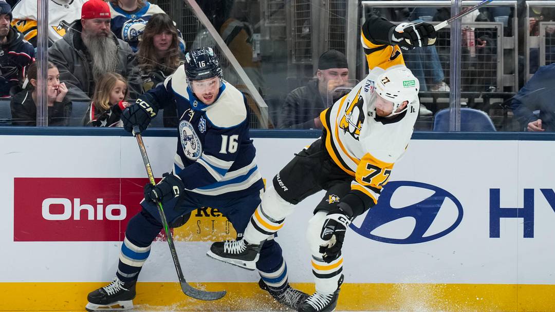Jan 4, 2026; Columbus, Ohio, USA;  Columbus Blue Jackets center Brendan Gaunce (16) skates for the puck against Pittsburgh Penguins defenseman Brett Kulak (77) in the first period at Nationwide Arena. Mandatory Credit: Aaron Doster-Imagn Images