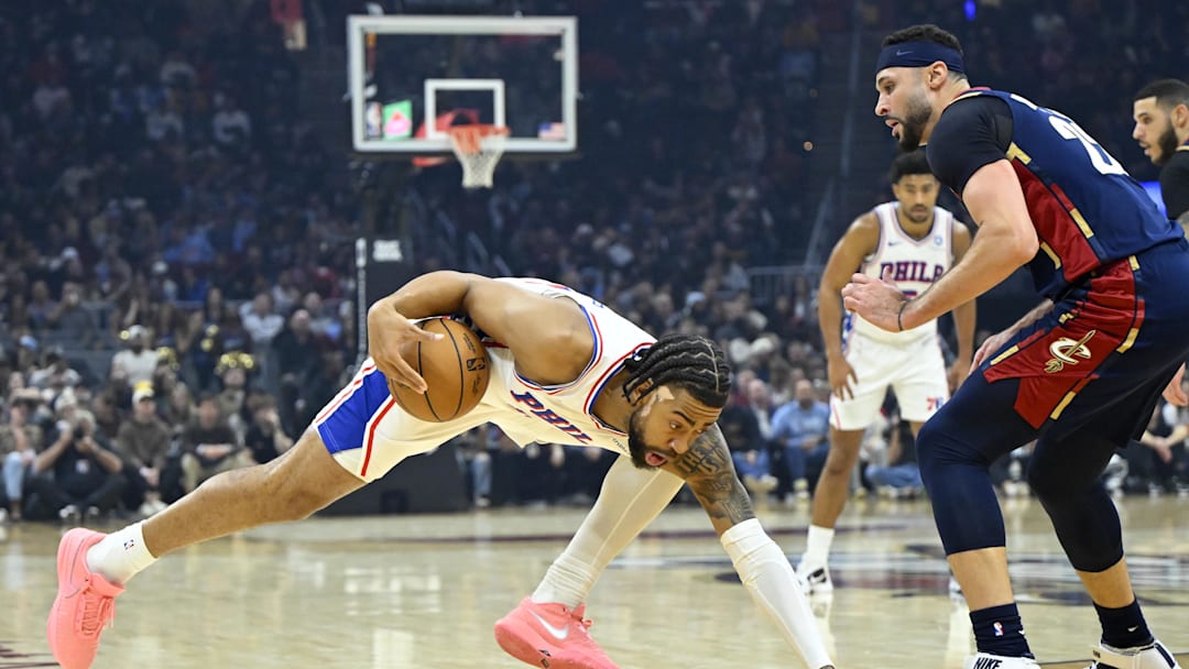 Nov 5, 2025; Cleveland, Ohio, USA; Philadelphia 76ers forward Trendon Watford (12) loses his balance beside Cleveland Cavaliers forward Larry Nance Jr. (22) in the first quarter at Rocket Arena. Mandatory Credit: David Richard-Imagn Images