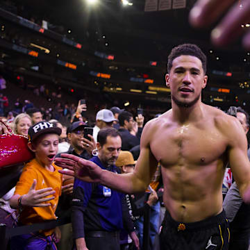 Dec 17, 2022; Phoenix, Arizona, USA; Phoenix Suns guard Devin Booker celebrates with the fans after defeating the New Orleans Pelicans at Footprint Center. Mandatory Credit: Mark J. Rebilas-Imagn Images