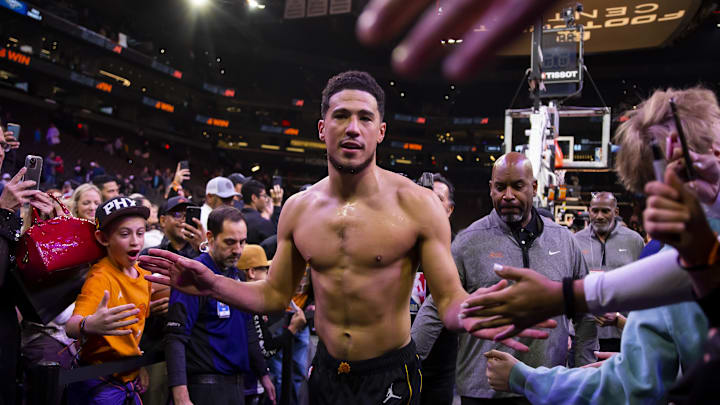 Dec 17, 2022; Phoenix, Arizona, USA; Phoenix Suns guard Devin Booker celebrates with the fans after defeating the New Orleans Pelicans at Footprint Center. Mandatory Credit: Mark J. Rebilas-Imagn Images