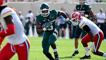 Sep 23, 2023; East Lansing, Michigan, USA;  Michigan State Spartans running back Nathan Carter (5) runs past Maryland Terrapins linebacker Fa'Najae Gotay (9) in the first quarter at Spartan Stadium. Mandatory Credit: Dale Young-USA TODAY Sports