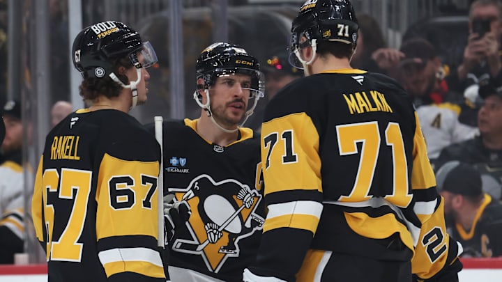 Apr 13, 2025; Pittsburgh, Pennsylvania, USA;  Pittsburgh Penguins right wing Rickard Rakell (67) and center Sidney Crosby (87) and center Evgeni Malkin (71) talk before a face-off against the Boston Bruins during the third period at PPG Paints Arena. Mandatory Credit: Charles LeClaire-Imagn Images