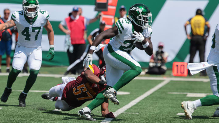 Aug 10, 2024; East Rutherford, New Jersey, USA; New York Jets running back Israel Abanikanda (25) carries the ball as Washington Commanders linebacker Anthony Pittman (57) tackles during the second half at MetLife Stadium. Mandatory Credit: Vincent Carchietta-USA TODAY Sports