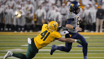 Nov 25, 2023; Waco, Texas, USA; West Virginia Mountaineers quarterback Garrett Greene (6) carries the ball as Baylor Bears linebacker Brooks Miller (41) defends during the second half at McLane Stadium. Mandatory Credit: Raymond Carlin III-Imagn Images