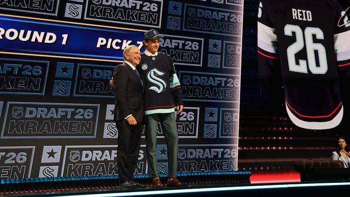 Jun 26, 2026; Buffalo, New York, USA; Chase Reid reacts beside NHL commissioner Gary Bettman after being selected with the seventh pick in the first round of the 2026 NHL Draft by the Seattle Kraken at KeyBank Center. Mandatory Credit: Timothy T. Ludwig-Imagn Images