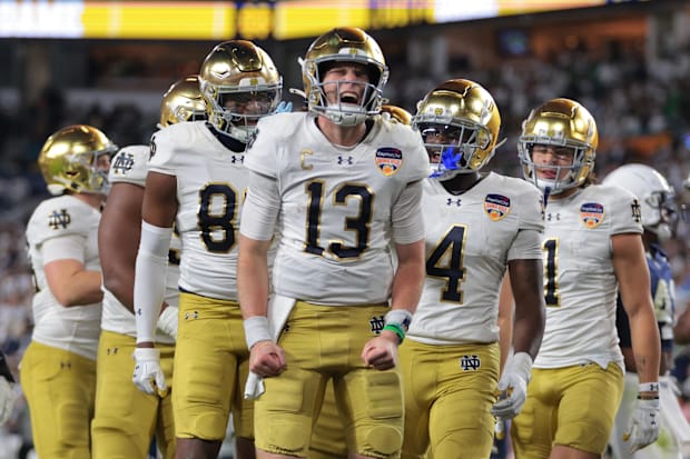 Notre Dame Fighting Irish quarterback Riley Leonard (13) celebrates a touchdown with teammates.
