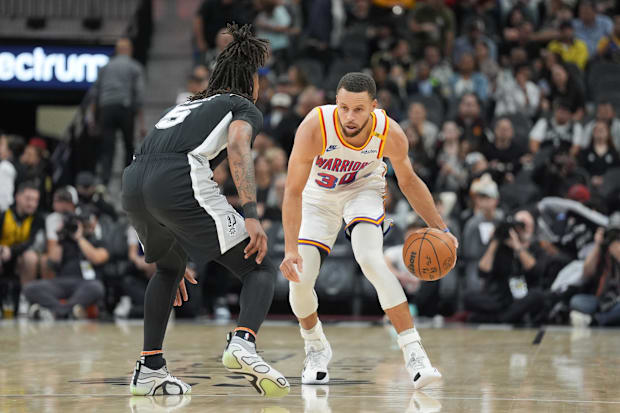 Golden State Warriors guard Stephen Curry (30) dribbles past San Antonio Spurs guard Stephon Castle (5).