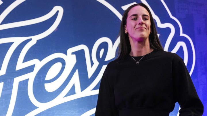 Aug 28, 2024; Indianapolis, Indiana, USA; Indiana Fever guard Caitlin Clark (22) walks past the photo backdrop before a game between the Indiana Fever and the Connecticut Sun at Gainbridge Fieldhouse. 