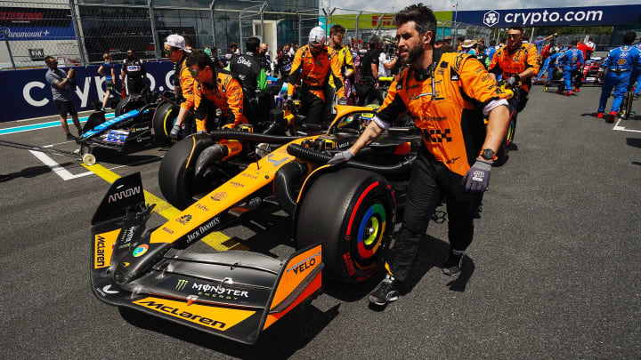 May 4, 2024; Miami Gardens, Florida, USA; Crewmembers push the car of McLaren driver Lando Norris (4) on the grid before the F1 Sprint Race at Miami International Autodrome. Mandatory Credit: John David Mercer-USA TODAY Sports