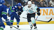 Vancouver Canucks defenseman Derek Forbort (27) checks Seattle Kraken forward Jordan Eberle (7).