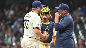 Aug 14, 2024; Milwaukee, Wisconsin, USA; Milwaukee Brewers pitching coach Chris Hook (84) comes out to talk with Milwaukee Brewers pitcher Jared Koenig (35) in the sixth inning against the Los Angeles Dodgers at American Family Field. Mandatory Credit: Michael McLoone-Imagn Images
