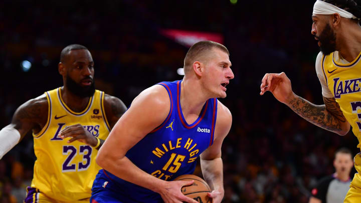 Apr 25, 2024; Los Angeles, California, USA; Denver Nuggets center Nikola Jokic (15) controls the ball against Los Angeles Lakers center Anthony Davis (3) and forward LeBron James (23) during the first half in game three of the first round for the 2024 NBA playoffs at Crypto.com Arena. Mandatory Credit: Gary A. Vasquez-USA TODAY Sports