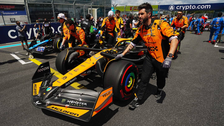 May 4, 2024; Miami Gardens, Florida, USA; Crewmembers push the car of McLaren driver Lando Norris (4) on the grid before the F1 Sprint Race at Miami International Autodrome. Mandatory Credit: John David Mercer-USA TODAY Sports