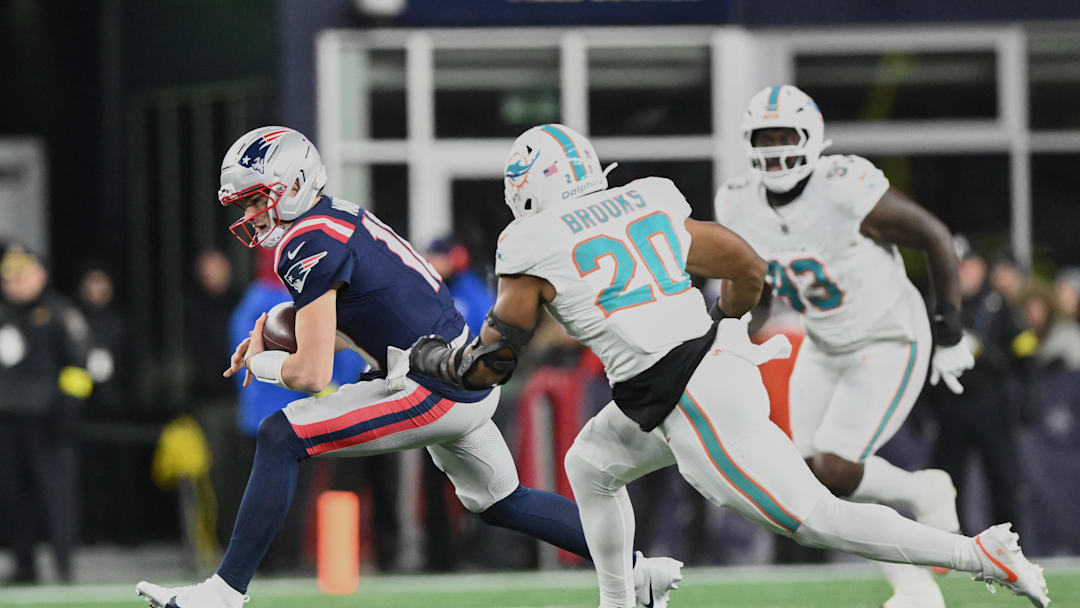 Jan 4, 2026; Foxborough, Massachusetts, USA; New England Patriots quarterback Drake Maye (10) scrambles against Miami Dolphins linebacker Jordyn Brooks (20) during the second quarter at Gillette Stadium. Mandatory Credit: Brian Fluharty-Imagn Images