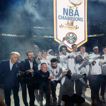 Oct 24, 2023; Denver, Colorado, USA; Denver Nuggets players and team personnel pose for a picture as their NBA Championship banner is lifted into the rafters before the game against the Los Angeles Lakers at Ball Arena. Mandatory Credit: Isaiah J. Downing-USA TODAY Sports