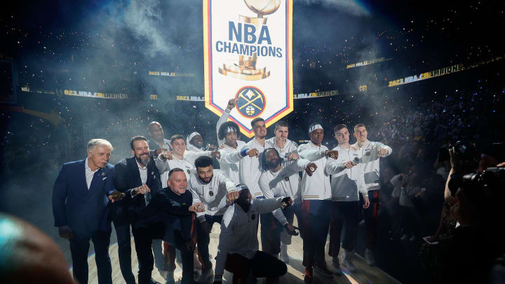 Oct 24, 2023; Denver, Colorado, USA; Denver Nuggets players and team personnel pose for a picture as their NBA Championship banner is lifted into the rafters before the game against the Los Angeles Lakers at Ball Arena. Mandatory Credit: Isaiah J. Downing-USA TODAY Sports