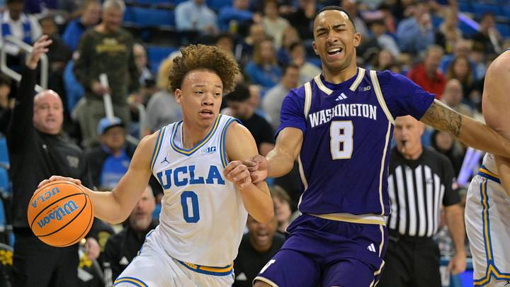 Feb 7, 2026; Los Angeles, California, USA;  UCLA Bruins guard Trent Perry (0) is defended by Washington Huskies forward Bryson Tucker (8) as he drives to the basket in the first half at Pauley Pavilion presented by Wescom Financial. Mandatory Credit: Jayne Kamin-Oncea-Imagn Images