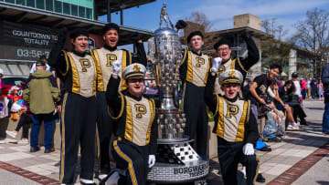 Purdue All-American Marching Band members take a photo the Borg-Warner Trophy