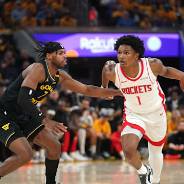 May 2, 2025; San Francisco, California, USA; Houston Rockets forward Amen Thompson (1) dribbles past Golden State Warriors guard Buddy Hield (7) in the second quarter of game six of the first round for the 2025 NBA Playoffs at Chase Center. Mandatory Credit: Cary Edmondson-Imagn Images
