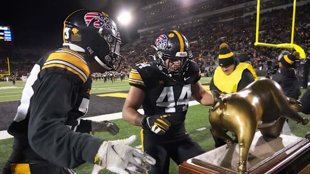 Iowa football players claim the Heartland trophy following a victory over the Wisconsin Badgers