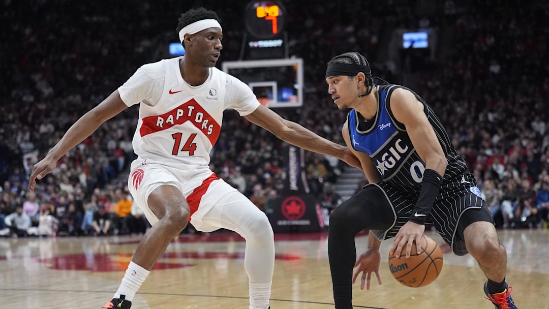 Dec 29, 2025; Toronto, Ontario, CAN; Orlando Magic guard Anthony Black (0) tries to dribble around Toronto Raptors guard Ja'Kobe Walter (14) during the second half at Scotiabank Arena. Mandatory Credit: John E. Sokolowski-Imagn Images