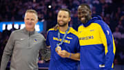Oct 11, 2024; San Francisco, California, USA; Golden State Warriors guard Stephen Curry (center) is flanked by head coach Steve Kerr and forward Draymond Green as he is presented his gold medal for his performance for Team USA at the 2024 Summer Olympics in Paris before taking on the Sacramento Kings at Chase Center. Mandatory Credit: D. Ross Cameron-Imagn Images