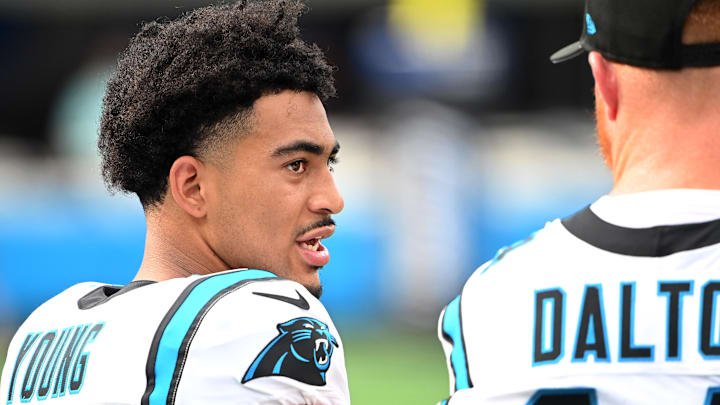 Carolina Panthers quarterbacks Bryce Young and Andy Dalton talk on the sidelines.