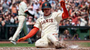 May 4, 2025; San Francisco, California, USA; San Francisco Giants catcher Patrick Bailey (14) slides into home plate to score a run against the Colorado Rockies during the fifth inning at Oracle Park.