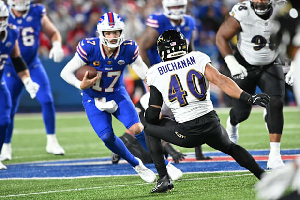 Buffalo Bills quarterback Josh Allen runs the ball, defended by Baltimore Ravens linebacker Teddye Buchanan.
