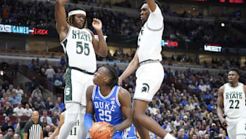 Nov 14, 2023; Chicago, Illinois, USA; Michigan State Spartans guard Tre Holloman (5) defends Duke Blue Devils forward Mark Mitchell (25) during the first half at United Center. Mandatory Credit: David Banks-Imagn Images