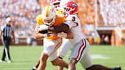 Tennessee Volunteers quarterback Joey Aguilar runs the ball as Georgia Bulldogs linebacker CJ Allen defends.