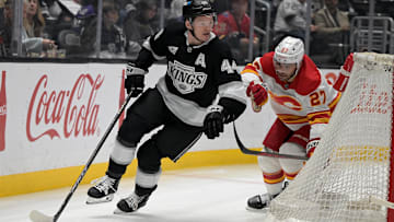 Apr 17, 2025; Los Angeles, California, USA;  Los Angeles Kings defenseman Mikey Anderson (44) keeps the puck from Calgary Flames right wing Matt Coronato (27) in the first period at Crypto.com Arena. Mandatory Credit: Jayne Kamin-Oncea-Imagn Images