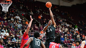 Feb 5, 2025; Blacksburg, Virginia, USA; Virginia Tech Hokies forward Mylyjael Poteat (34) shoots a shot as Southern Methodist Mustangs center Samet Yigitoglu (24) defends during the second half at Cassell Coliseum. Mandatory Credit: Brian Bishop-Imagn Images