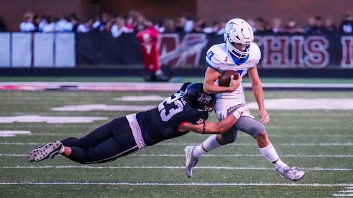 Mukwonago quarterback Mason Kelley (13) is forced out of bounds by Muskego's Thomas Gover (23) during the game at Muskego on Friday, Sept. 13, 2024. Mukwonago quarterback Mason Kelley (13) is forced out of bounds by Muskego's Thomas Gover (23) during the game at Muskego on Friday, Sept. 13, 2024.