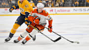 Mar 20, 2025; Nashville, Tennessee, USA;  Anaheim Ducks defenseman Pavel Mintyukov (34) steals the puck from Nashville Predators right wing Michael McCarron (47) during the first period at Bridgestone Arena. Mandatory Credit: Steve Roberts-Imagn Images