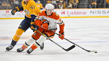 Mar 20, 2025; Nashville, Tennessee, USA;  Anaheim Ducks defenseman Pavel Mintyukov (34) steals the puck from Nashville Predators right wing Michael McCarron (47) during the first period at Bridgestone Arena. Mandatory Credit: Steve Roberts-Imagn Images