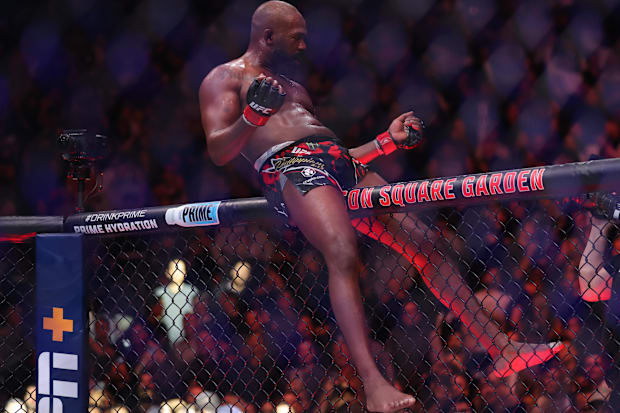 Jon Jones (red gloves) celebrates defeating Stipe Miocoic (blue gloves) in the heavyweight bout during UFC 309.