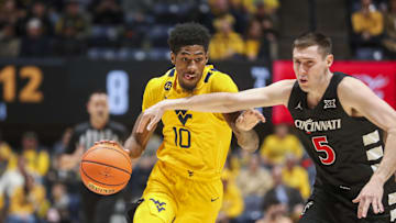 Feb 19, 2025; Morgantown, West Virginia, USA; West Virginia Mountaineers guard Sencire Harris (10) drives against Cincinnati Bearcats guard CJ Fredrick Jr. (5) during the first half at WVU Coliseum. Mandatory Credit: Ben Queen-Imagn Images