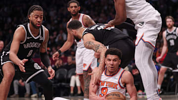 Apr 13, 2025; Brooklyn, New York, USA; New York Knicks forward Kevin McCullar Jr. (9) secures a loose ball in front of Brooklyn Nets forward Trendon Watford (9) during the second half at Barclays Center. Mandatory Credit: Vincent Carchietta-Imagn Images
