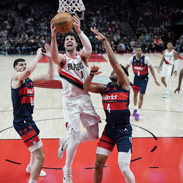 Mar 17, 2025; Portland, Oregon, USA: Portland Trail Blazers small forward Deni Avdija (8) shoots against Washington Wizards guard Jaylen Martin (4) and power forward Tristan Vukcevic (00) during the first half at Moda Center. Mandatory Credit: Soobum Im-Imagn Images