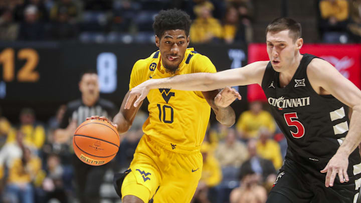 Feb 19, 2025; Morgantown, West Virginia, USA; West Virginia Mountaineers guard Sencire Harris (10) drives against Cincinnati Bearcats guard CJ Fredrick Jr. (5) during the first half at WVU Coliseum. Mandatory Credit: Ben Queen-Imagn Images